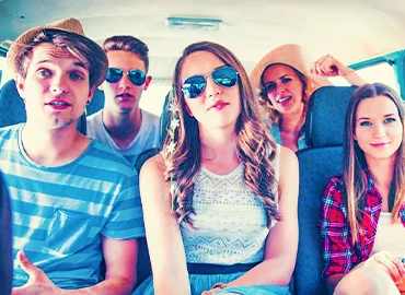 A group of people smiling and laughing in a taxi cab.